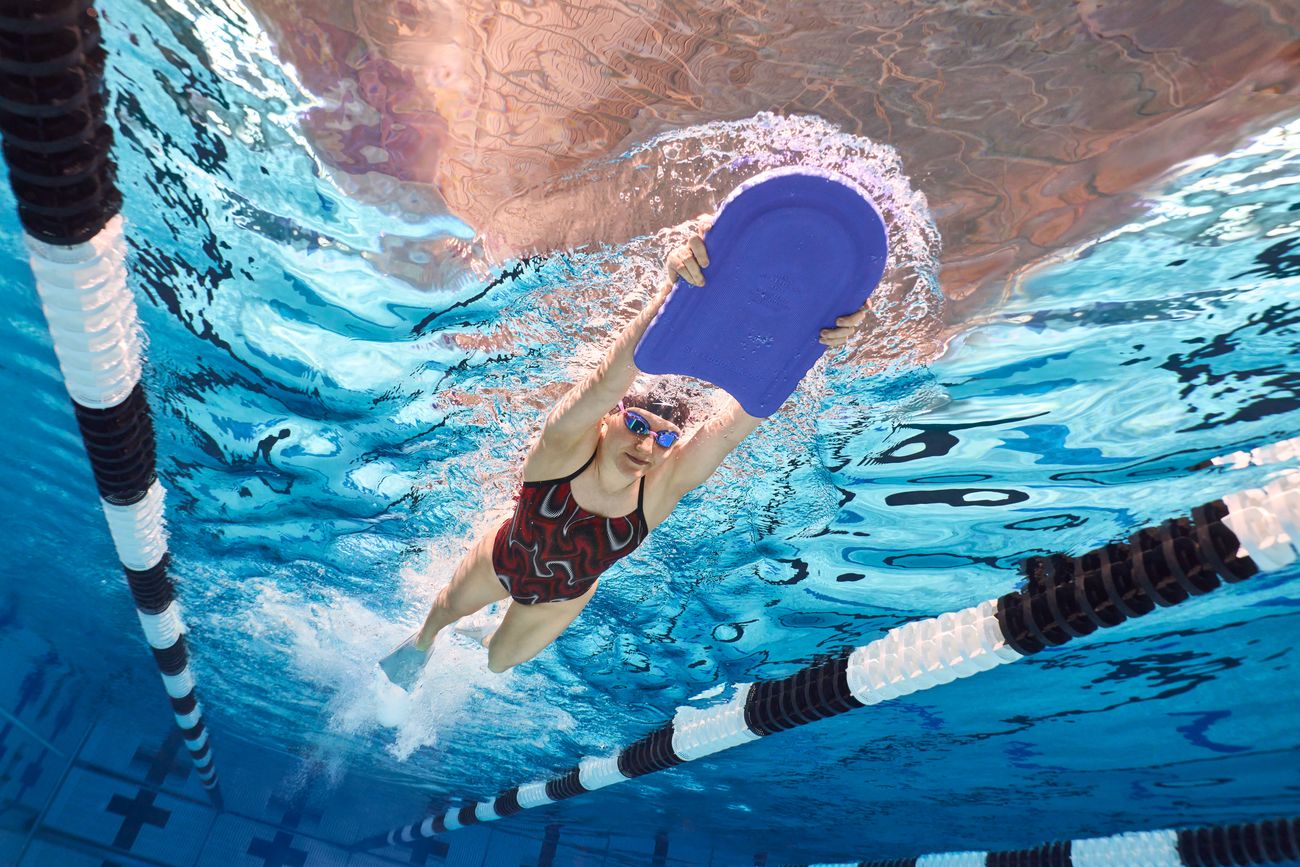 Swim campaign: a competitive swimmer mid-stroke in a racing lane